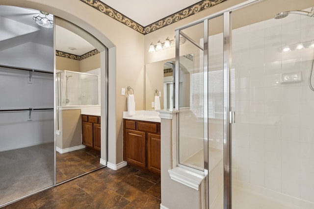 5312 Ridgeson Dr, Mckinney, TX 75071 - bathroom featuring vanity, a stall shower, a walk in closet, and stone finish floors