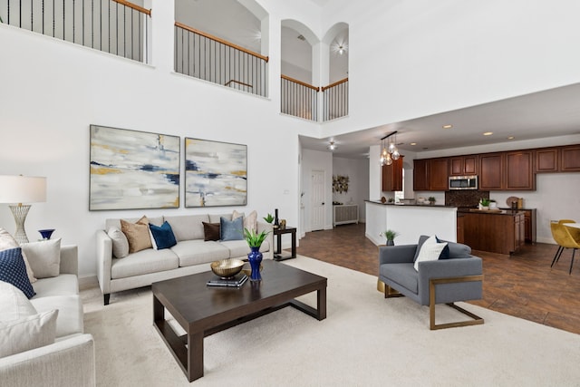 5312 Ridgeson Dr, Mckinney, TX 75071 - living area featuring a towering ceiling, a chandelier, ceiling fan, recessed lighting, and stone finish flooring