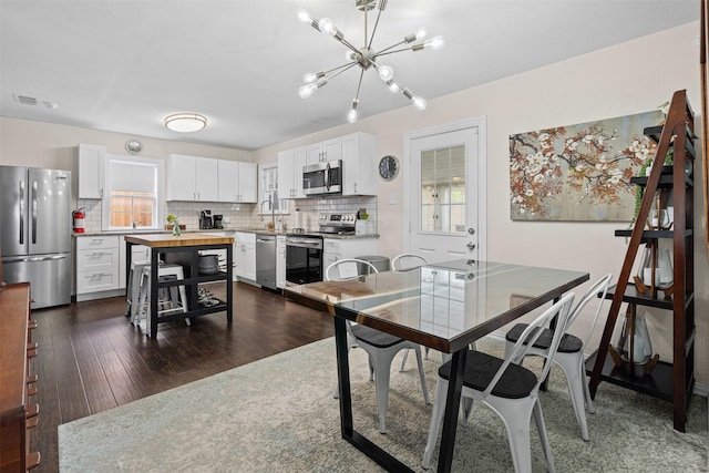 4204 Geddes Ave, Fort Worth, TX 76107 - dining room featuring a chandelier, dark wood finished floors, and healthy amount of natural light