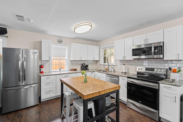 4204 Geddes Ave, Fort Worth, TX 76107 - kitchen featuring appliances with stainless steel finishes, tasteful backsplash, and white cabinets