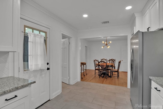 208 Arthur Ave, Shreveport, LA 71105 - kitchen with freestanding refrigerator, white cabinets, light stone counters, recessed lighting, and crown molding