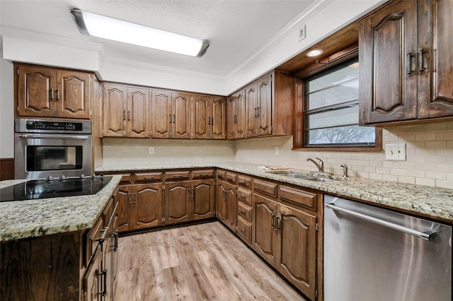 1632 Andy Dr, Sherman, TX 75092 - kitchen with appliances with stainless steel finishes, crown molding, light wood-style flooring, decorative backsplash, and light stone countertops