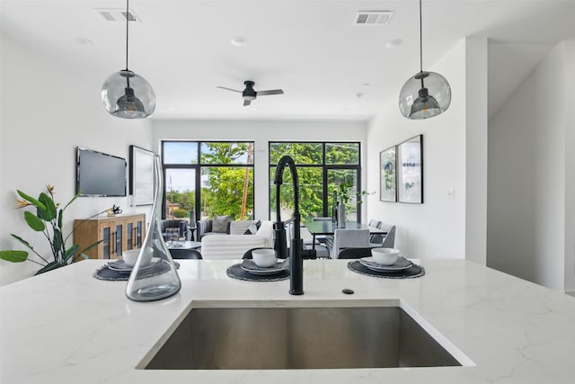 430 E 8th Unit 101, Dallas, TX 75203 - kitchen with open floor plan, light stone countertops, decorative light fixtures, ceiling fan, and recessed lighting