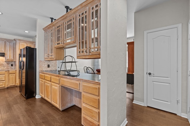 5820 Woodwind Dr, Plano, TX 75093 - kitchen with black fridge, dark wood-style flooring, tasteful backsplash, glass insert cabinets, and recessed lighting