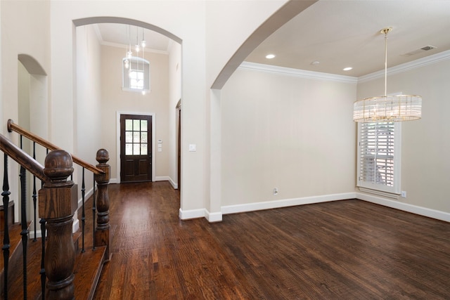 11560 Mirage Ln, Frisco, TX 75033 - entryway featuring ornamental molding, dark wood finished floors, arched walkways, a chandelier, and a high ceiling
