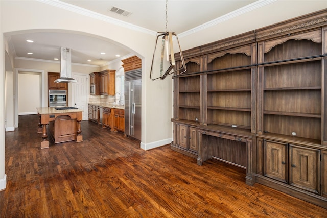 11560 Mirage Ln, Frisco, TX 75033 - kitchen with island exhaust hood, appliances with stainless steel finishes, arched walkways, a breakfast bar, and dark wood-style floors