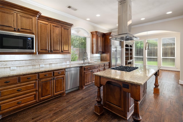 11560 Mirage Ln, Frisco, TX 75033 - kitchen featuring built in appliances, a kitchen breakfast bar, island exhaust hood, light stone countertops, and brown cabinets