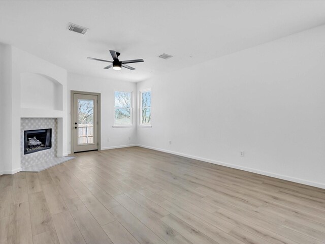 9741 Indian Canyon Dr, Plano, TX 75025 - unfurnished living room with a ceiling fan, light wood-style floors, and a tile fireplace