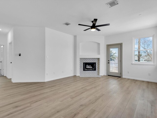 9741 Indian Canyon Dr, Plano, TX 75025 - unfurnished living room featuring a ceiling fan, light wood-style floors, and a tile fireplace