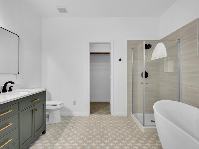 9741 Indian Canyon Dr, Plano, TX 75025 - full bath featuring a stall shower, vanity, a spacious closet, a soaking tub, and tile patterned floors