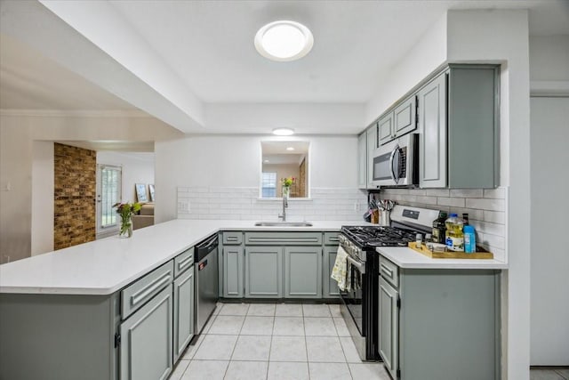 7920 Donegal Ln, North Richland Hills, TX 76180 - kitchen with stainless steel appliances, a peninsula, gray cabinets, and backsplash