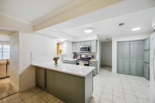 7920 Donegal Ln, North Richland Hills, TX 76180 - kitchen featuring stainless steel appliances, tasteful backsplash, a peninsula, light tile patterned floors, and light countertops