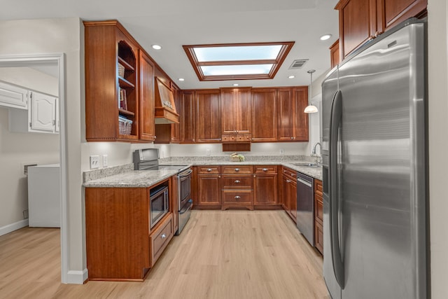 2305 Delmar Dr, Plano, TX 75075 - kitchen featuring appliances with stainless steel finishes, light wood-style flooring, light stone counters, brown cabinetry, and recessed lighting