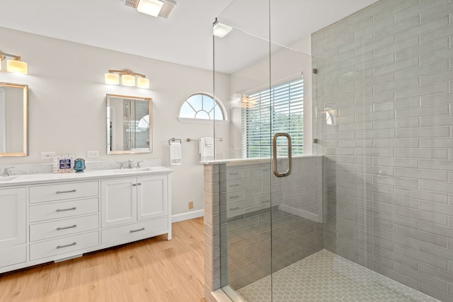 2305 Delmar Dr, Plano, TX 75075 - bathroom featuring double vanity, wood finished floors, and a stall shower