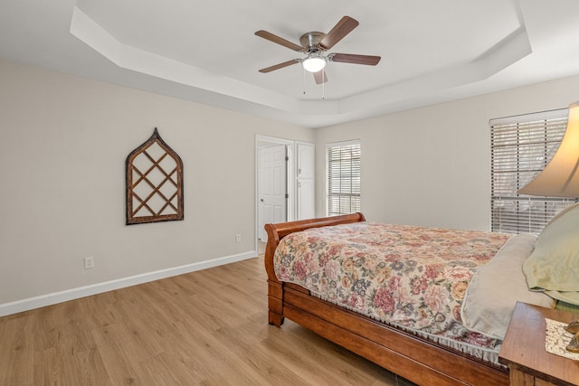 2305 Delmar Dr, Plano, TX 75075 - bedroom featuring a tray ceiling, light wood-type flooring, and ceiling fan