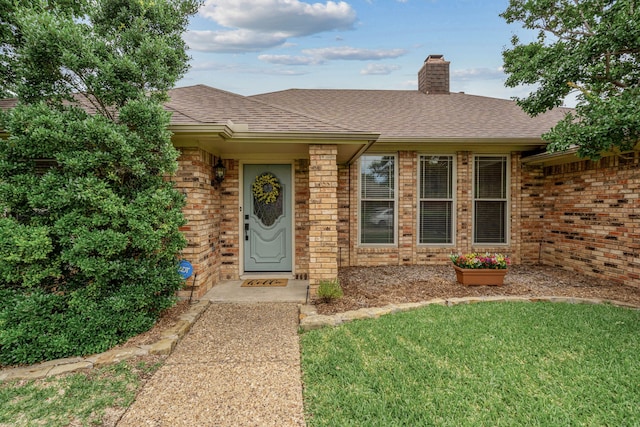 2305 Delmar Dr, Plano, TX 75075 - entrance to property with brick siding, roof with shingles, a chimney, and a yard