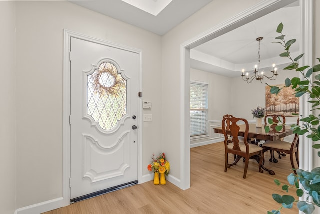 2305 Delmar Dr, Plano, TX 75075 - entrance foyer with a chandelier, light wood-style flooring, and a tray ceiling