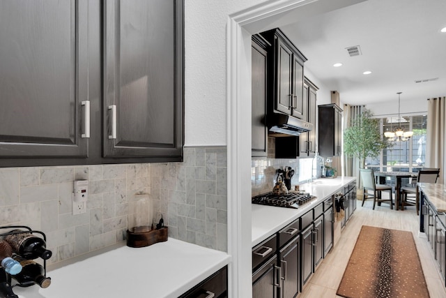 1809 Lake Glen Trl, Mansfield, TX 76063 - kitchen featuring gas cooktop, a chandelier, light countertops, decorative backsplash, and under cabinet range hood