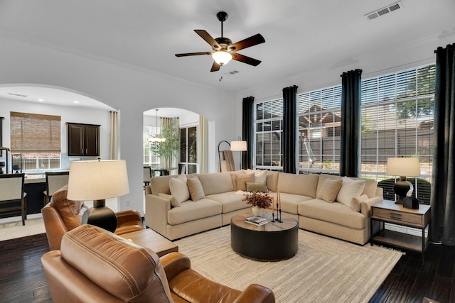 1809 Lake Glen Trl, Mansfield, TX 76063 - living room featuring arched walkways, ceiling fan, dark wood-style floors, a chandelier, and ornamental molding