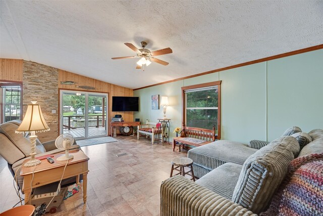 200 Dogwood Trl, Murchison, TX 75778 - living room with lofted ceiling, plenty of natural light, a ceiling fan, wood walls, and stone finish flooring