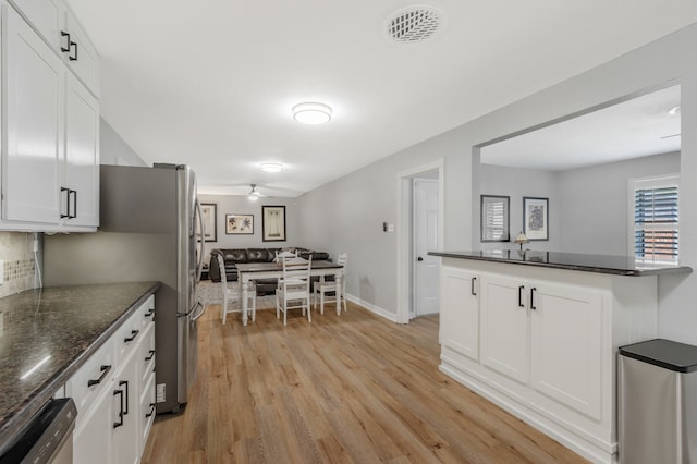 7424 Bridges Ave, Richland Hills, TX 76118 - kitchen featuring stainless steel dishwasher, light wood-type flooring, white cabinets, backsplash, and dark stone countertops