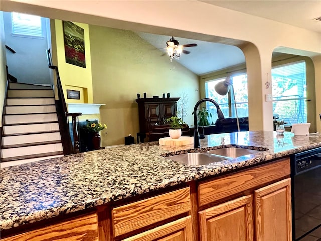 4924 Marsh Harrier Ave, Grand Prairie, TX 75052 - kitchen with ceiling fan, dark stone countertops, dishwasher, vaulted ceiling, and brown cabinetry