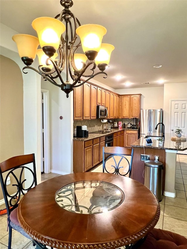 4924 Marsh Harrier Ave, Grand Prairie, TX 75052 - dining area with a chandelier, light tile patterned flooring, and arched walkways