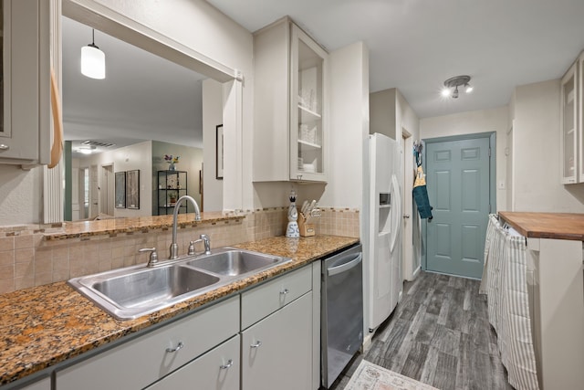 1218 Ridgeway Dr, Richardson, TX 75080 - kitchen with stainless steel dishwasher, dark wood-style floors, tasteful backsplash, white refrigerator with ice dispenser, and glass insert cabinets