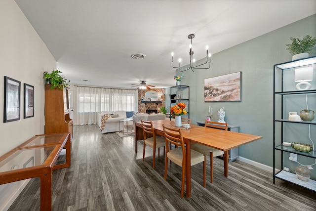 1218 Ridgeway Dr, Richardson, TX 75080 - dining area featuring dark wood-style flooring, a fireplace, a chandelier, and ceiling fan
