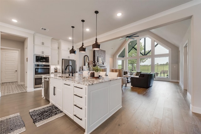 12480 Palmer Dr, Fort Worth, TX 76179 - kitchen with stainless steel appliances, a ceiling fan, open floor plan, wood finished floors, and white cabinetry
