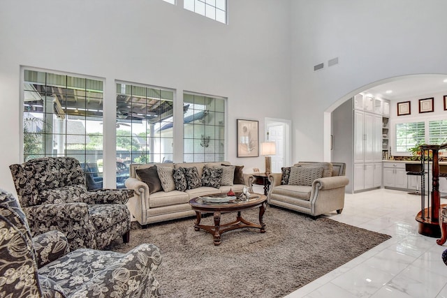 2310 Auburn Ct, Sherman, TX 75092 - living room with arched walkways, a towering ceiling, and light marble finish flooring