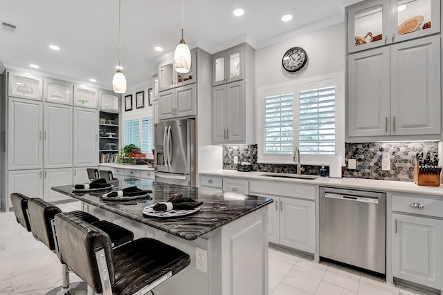 2310 Auburn Ct, Sherman, TX 75092 - kitchen featuring appliances with stainless steel finishes, ornamental molding, light marble finish flooring, tasteful backsplash, and a breakfast bar area
