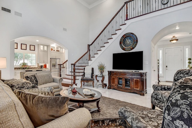 2310 Auburn Ct, Sherman, TX 75092 - living room featuring arched walkways, a high ceiling, stairs, and marble finish flooring