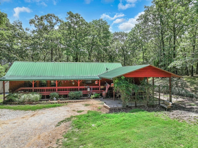 1605 County Road 1195, Yantis, TX 75497 - view of front of property featuring log siding, a metal roof, a front yard, and dirt driveway