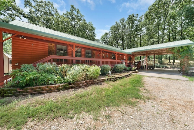1605 County Road 1195, Yantis, TX 75497 - view of front facade with a carport, driveway, a metal roof, and log exterior