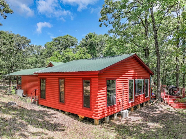 1605 County Road 1195, Yantis, TX 75497 - view of home's exterior featuring a metal roof, view of wooded area, and a deck