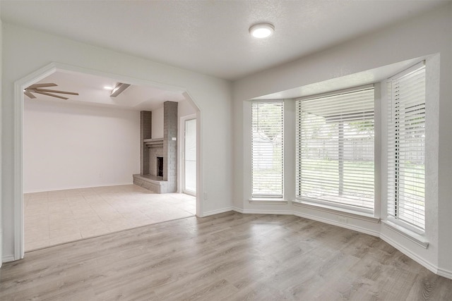 3925 Singleleaf Ln, Fort Worth, TX 76133 - unfurnished living room featuring a fireplace and light wood-style floors