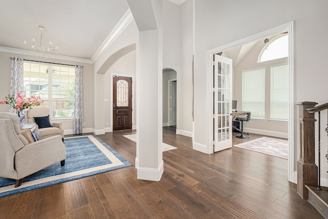 1251 Castle Dr, Prosper, TX 75078 - entryway featuring arched walkways, plenty of natural light, a chandelier, crown molding, and wood finished floors