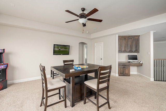 1251 Castle Dr, Prosper, TX 75078 - dining space with light colored carpet, ceiling fan, arched walkways, and built in study area