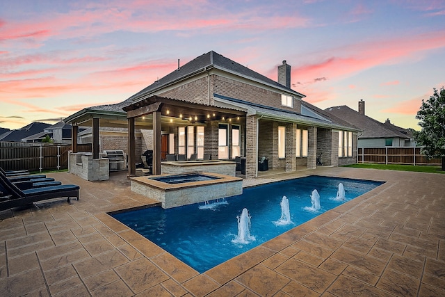 1251 Castle Dr, Prosper, TX 75078 - back of property at dusk with an outdoor kitchen, a patio, brick siding, a gazebo, and a chimney