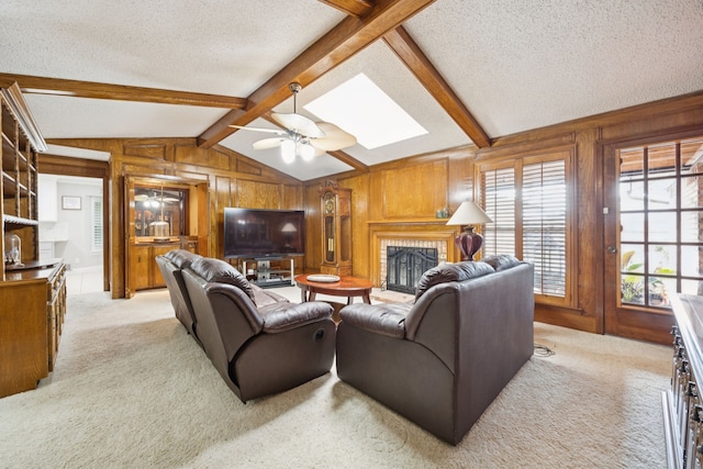 1301 Warwick St, Garland, TX 75040 - living room with a fireplace, light carpet, a textured ceiling, wooden walls, and a skylight