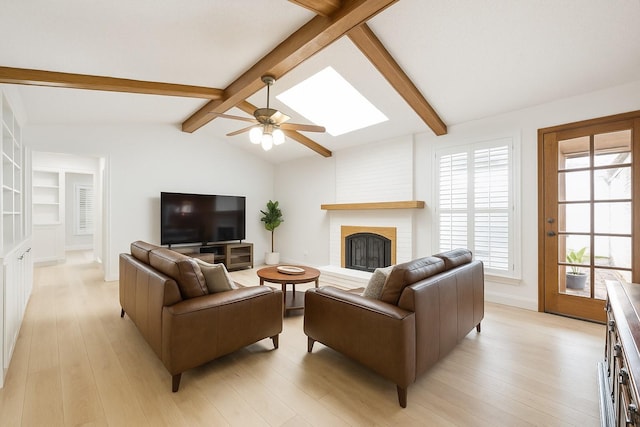 1301 Warwick St, Garland, TX 75040 - living area with a fireplace, light wood-style floors, a ceiling fan, and a skylight
