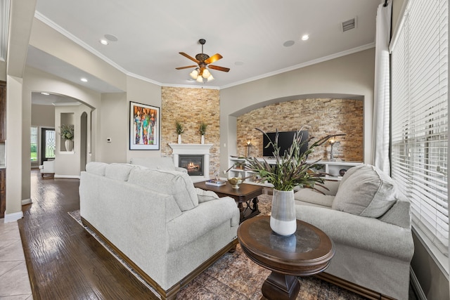 881 Derick Ln, Prosper, TX 75078 - living area with a glass covered fireplace, a ceiling fan, arched walkways, crown molding, and wood finished floors