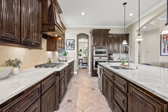 881 Derick Ln, Prosper, TX 75078 - kitchen featuring arched walkways, appliances with stainless steel finishes, decorative backsplash, crown molding, and pendant lighting
