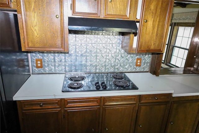 130 Golfcrest St, Rusk, TX 75785 - kitchen with black electric cooktop, under cabinet range hood, light countertops, and decorative backsplash