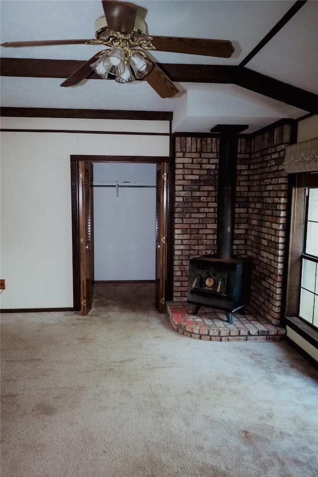 130 Golfcrest St, Rusk, TX 75785 - unfurnished living room with carpet, a wood stove, beam ceiling, and a ceiling fan