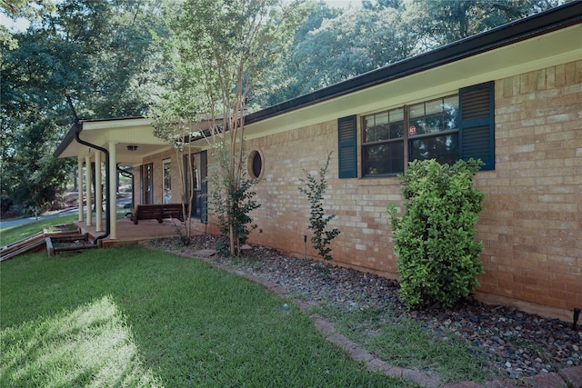 130 Golfcrest St, Rusk, TX 75785 - view of home's exterior with a lawn, brick siding, and a porch