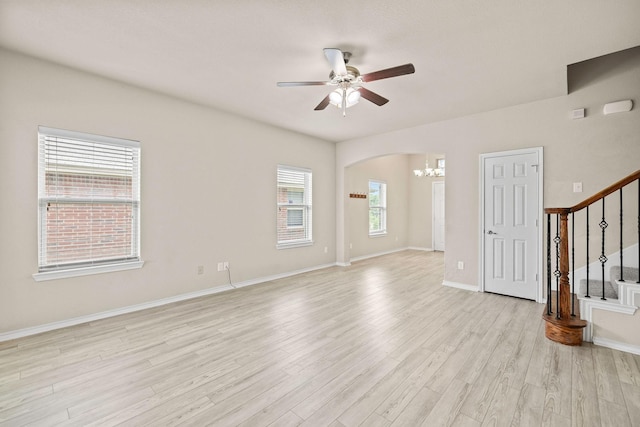5365 Saba Dr, Fort Worth, TX 76119 - unfurnished room featuring a chandelier, stairway, ceiling fan, light wood-style flooring, and arched walkways
