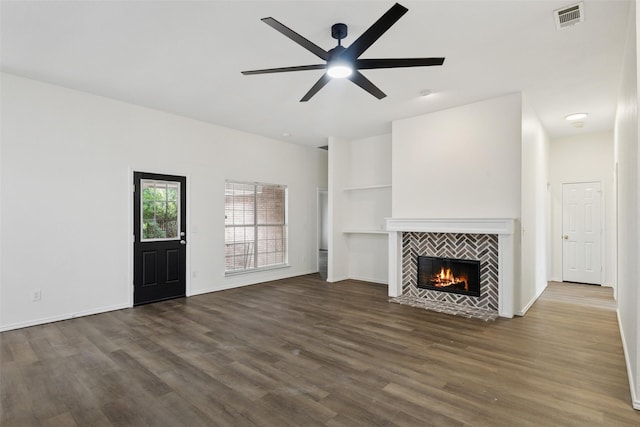 9942 Laurel Ln, Frisco, TX 75035 - unfurnished living room featuring dark wood finished floors, a tiled fireplace, ceiling fan, and built in shelves