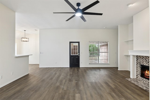 9942 Laurel Ln, Frisco, TX 75035 - unfurnished living room with a ceiling fan, dark wood-style flooring, a tile fireplace, and a chandelier